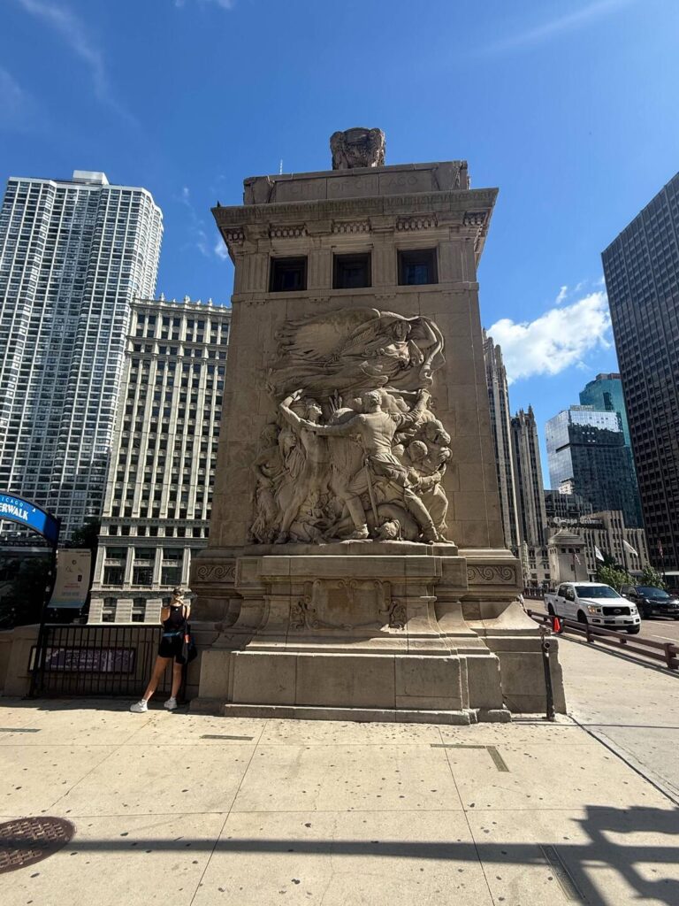 Chicago bridge sculpture with city skyline backdrop.