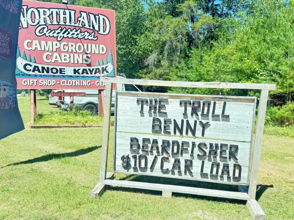 Northland Outfitter campground sign with forest background.