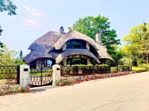Unique house with thatched roof and stone facade.