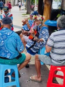 People playing ukuleles in colorful outfits outdoors