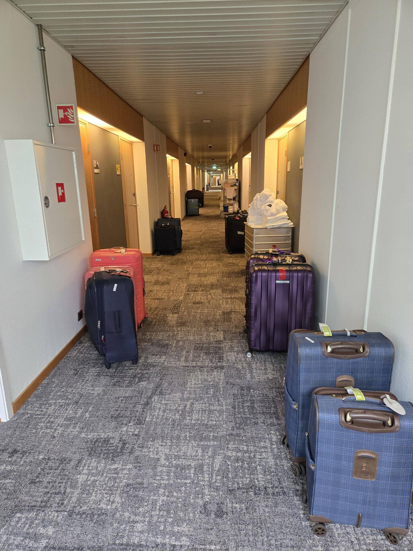 Hotel hallway with suitcases lined up.