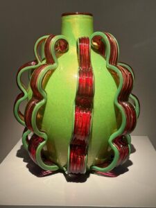 Green sculpture with red wavy accents on display.