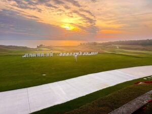 Sunset over golf course with seating area.