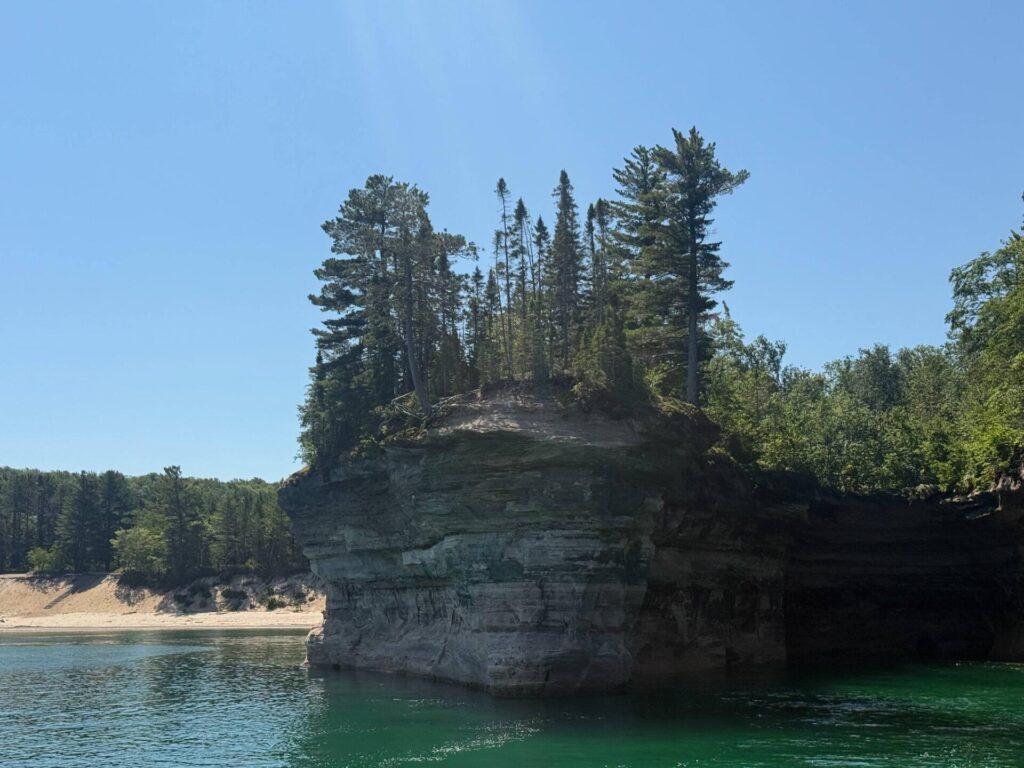 Rocky cliff with trees by clear water
