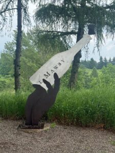 Bottle sculpture in lush green landscape