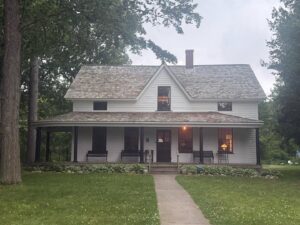 Historic white farmhouse surrounded by trees