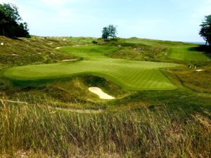 Lush golf course landscape with green hills.