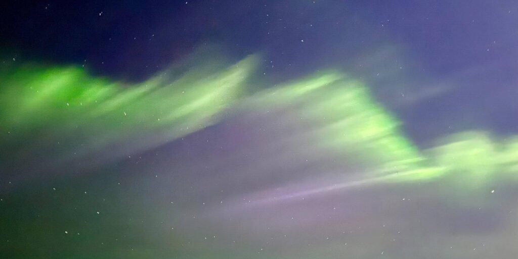 Green aurora borealis lights in night sky