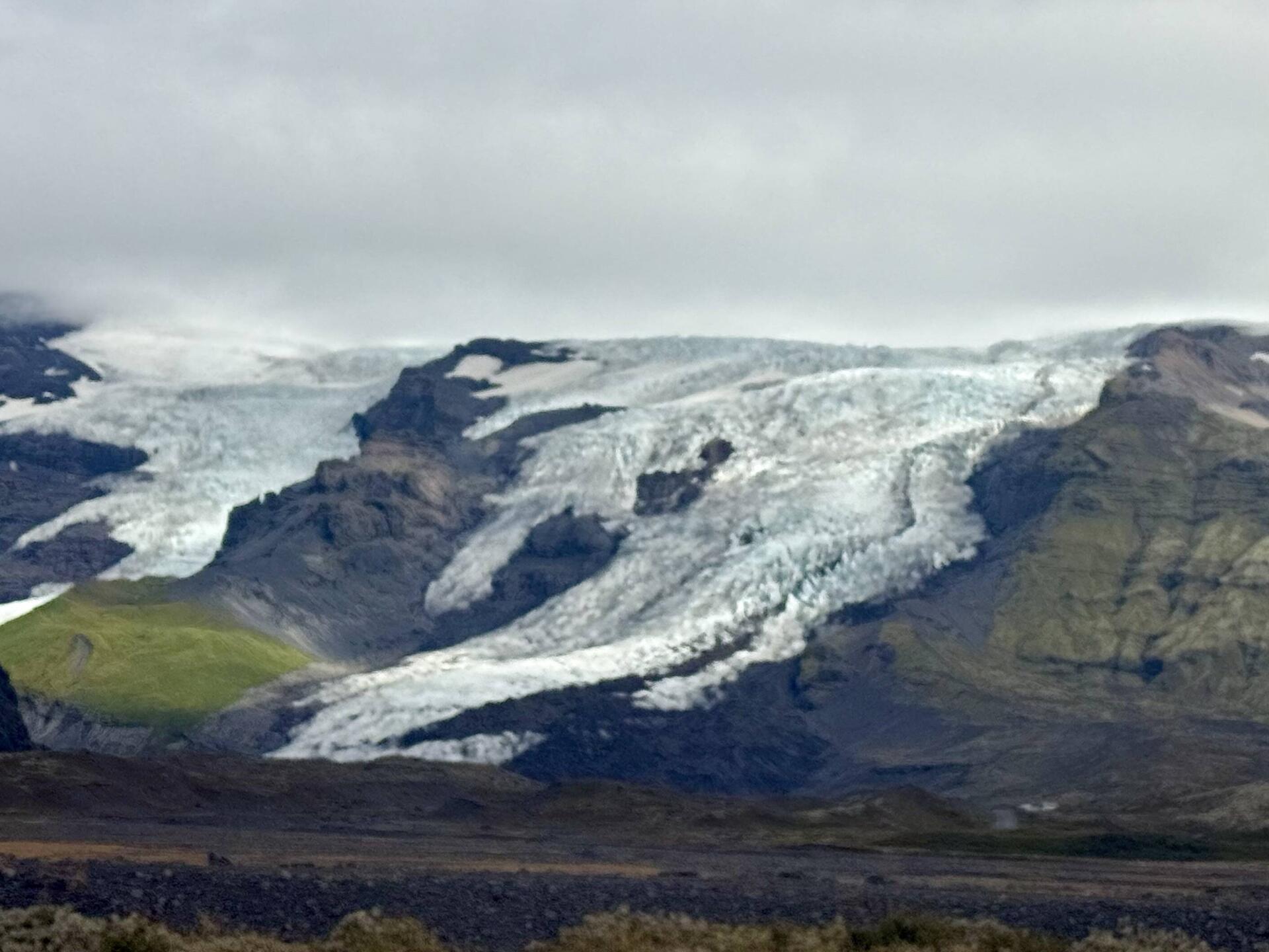 Snowy glacier on a rugged mountain landscape.