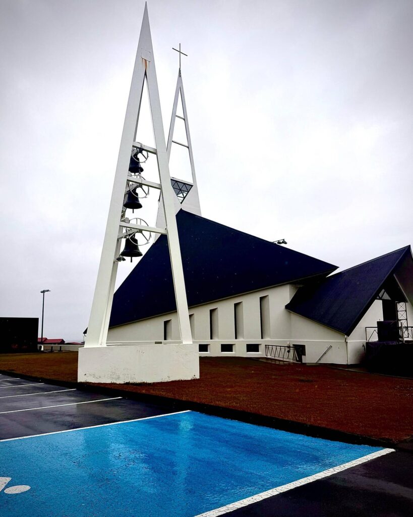 Modern church with sharp steeples and parking lot