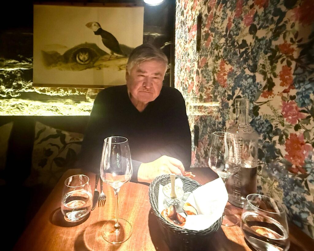 Man dining at a cozy, warmly-lit restaurant table.