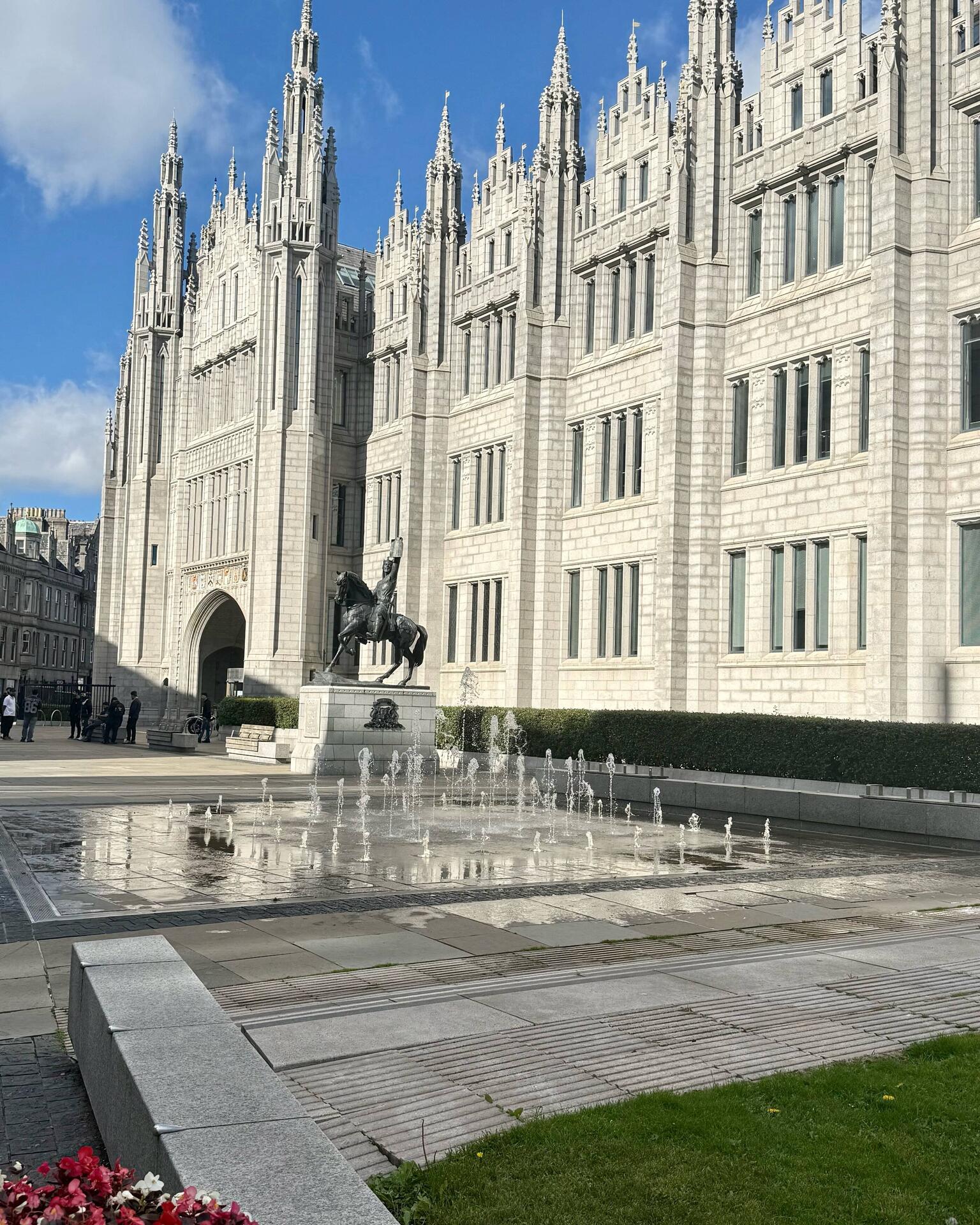Historic building with statue and water fountains.