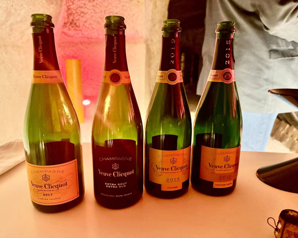 Four Veuve Clicquot champagne bottles displayed on table.