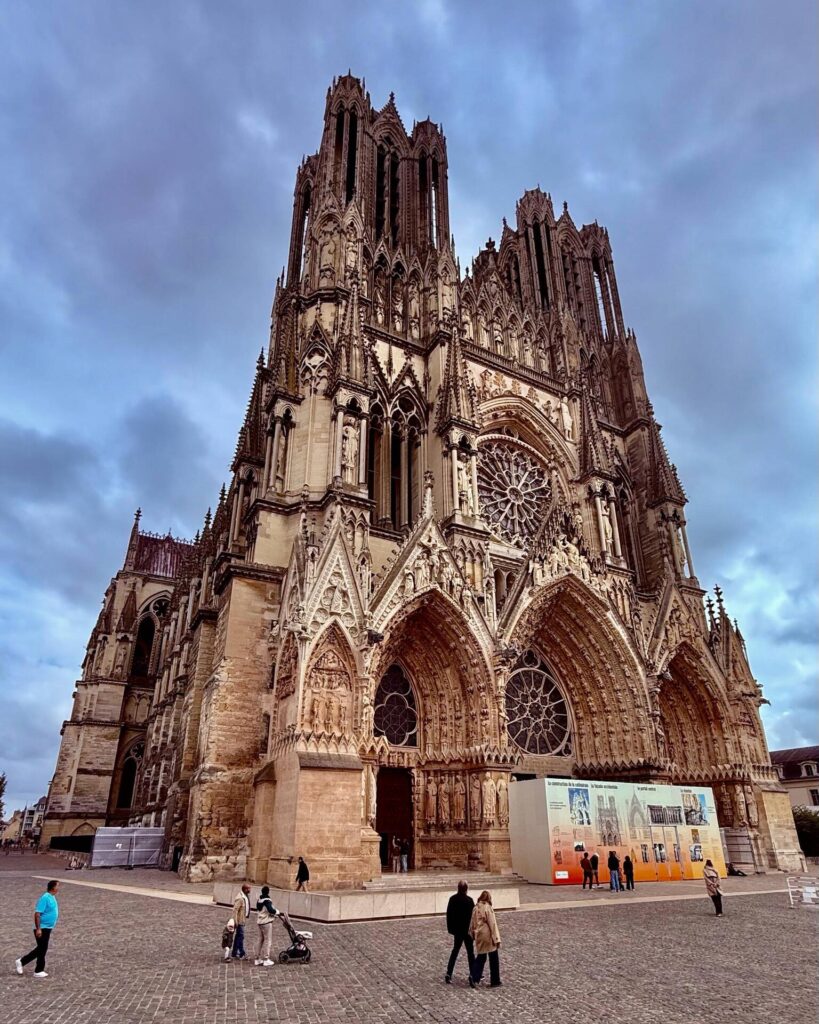 Gothic cathedral facade with ornate architecture, people walking.
