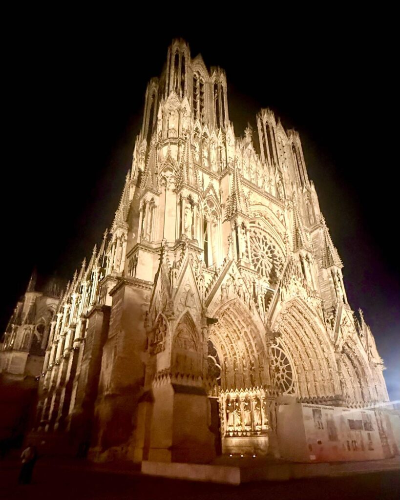 Illuminated Gothic cathedral facade at night.