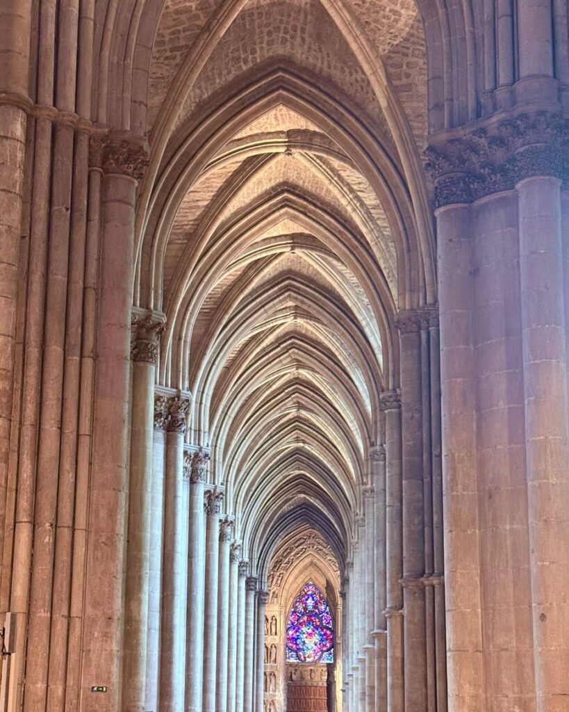 Gothic cathedral interior with stained glass window.