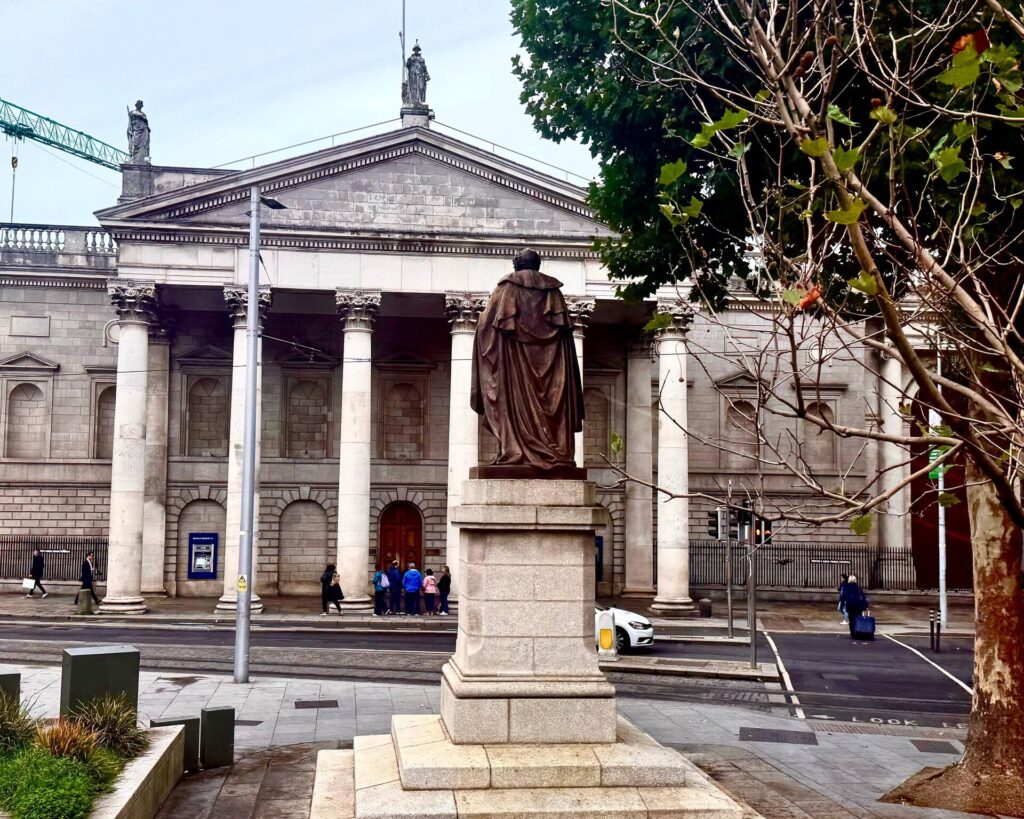Statue in front of historic building with columns.