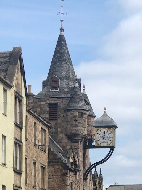 Historic building with clock tower and weather vane.