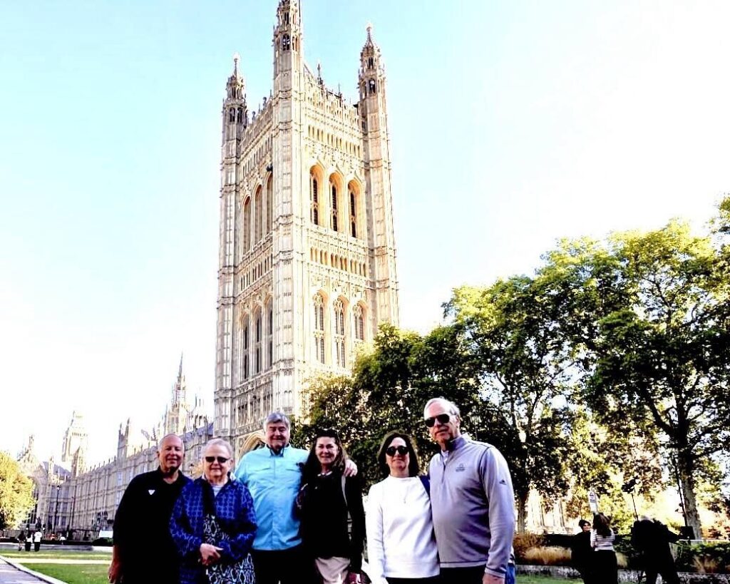 Group near UK's Westminster Palace, sunny day.