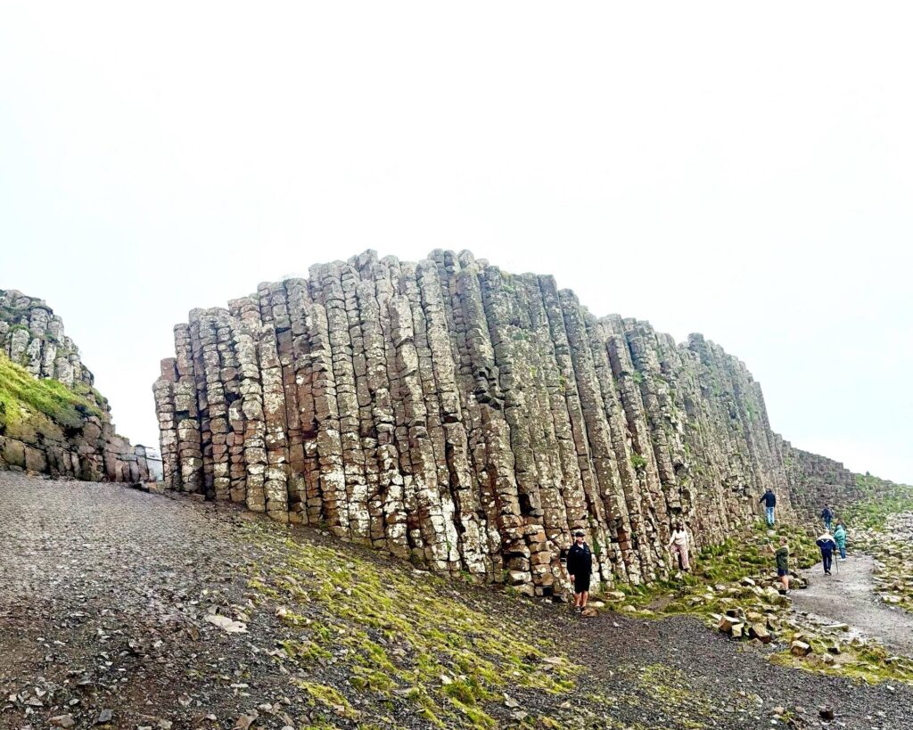 Tourists explore Giant's Causeway basalt columns.