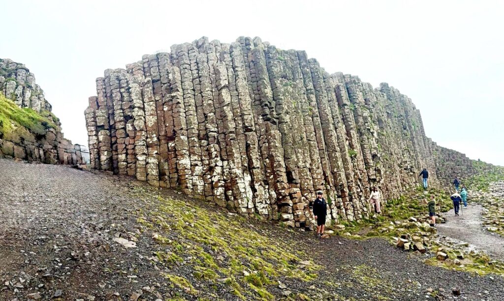Tourists explore Giant's Causeway basalt columns.
